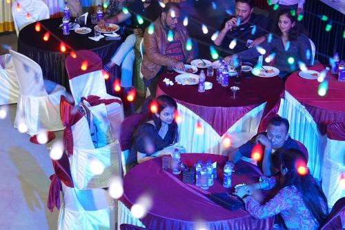 a group of people sitting at tables at a party at Kuruva Island Resort And Spa - By KABINI BREEZE in Mananthavady
