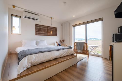 1 dormitorio con cama, escritorio y ventana en 縁 EN - The Suites en Furano