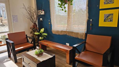 a living room with two chairs and a wooden table at Century House in Da Lat