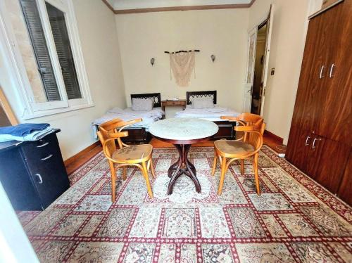 a room with a table and chairs in a room at ARAB Hostel For Men onlyغرف خاصة للرجال فقط 仅限男士 女士不允许 in Alexandria