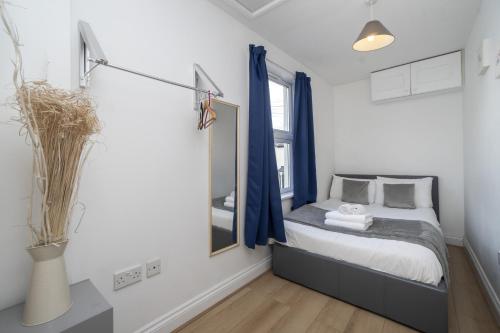 een kleine slaapkamer met een bed en een spiegel bij Contemporary 2 bed flat in Bristol, Free Parking in Bristol