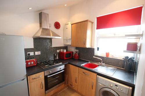 cocina con fregadero y fogones horno superior en Contemporary 2 bed flat in Bristol, Free Parking, en Bristol