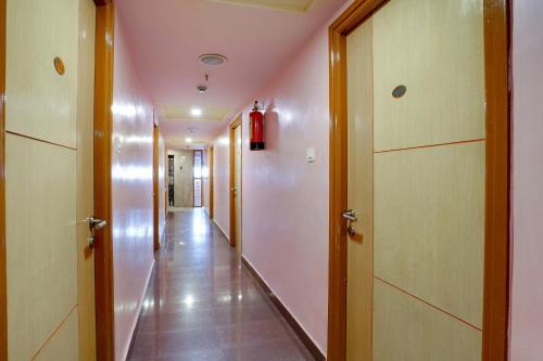 un couloir avec un long couloir à deux portes dans l'établissement OYO Shanthaa Residency, à Surūrnagar