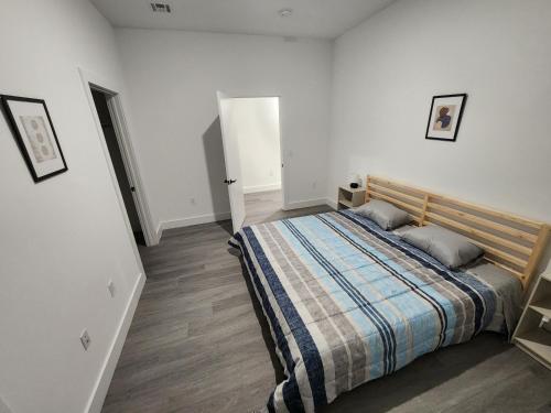 ein Schlafzimmer mit einem Bett in einem weißen Zimmer in der Unterkunft Luxury 2 bedroom apartment, close to NYC! in Bayonne