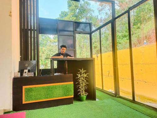 a man is sitting at a desk in an office at MUNNAR MISTY BLOW in Munnar