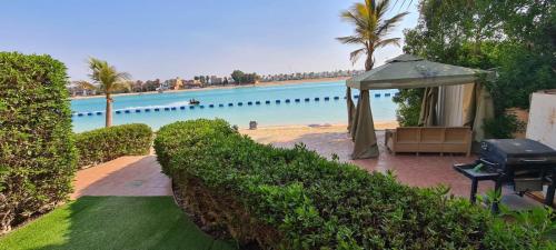 uma piscina com um gazebo e a água em درة العروس شاليه شاطئ البرادايس em Durat Alarous