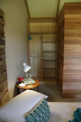 a bedroom with a bed and a table with a lamp at Gemstone Farm in Plettenberg Bay
