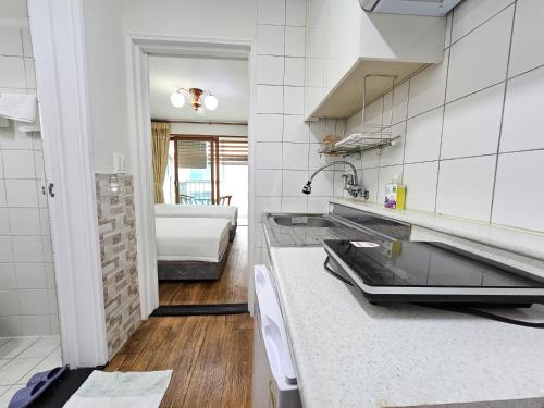 a kitchen with a sink and a counter top at Seongsan Sunrise Pension in Seogwipo