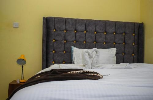 a bedroom with a large bed with a large headboard at The escape, nyahururu. in Nyahururu
