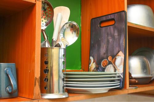 a cup with plates and utensils in a cabinet at The escape, nyahururu. in Nyahururu