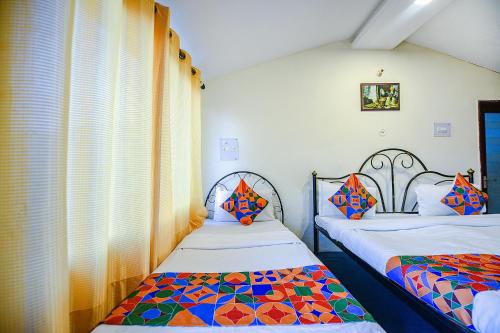 2 camas individuais num quarto com uma janela em FabExpress 180 Degree Resort em Mussoorie