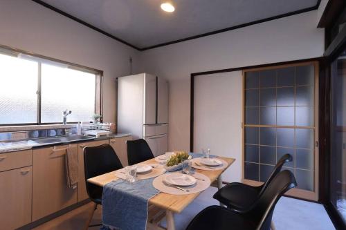 a kitchen with a wooden table with chairs and a tableasteryasteryasteryasteryastery at くつろぎのお宿「やわや」 in Himi