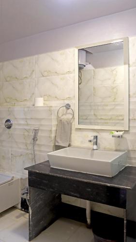 a bathroom with a sink and a mirror at Hotel Executive Tower in Kolkata