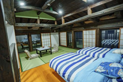 two beds in a room with a table and chairs at 一宿一景一生縁-千葉県四街道店 in Yotsukaidō