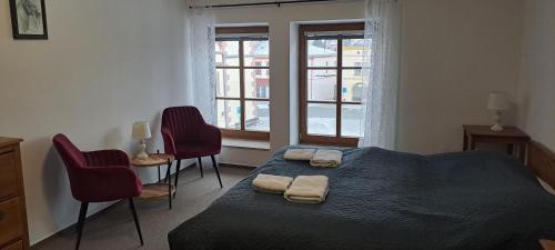 a bedroom with a bed with two towels on it at Penzion Adler in Dobruška