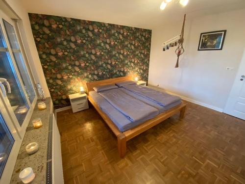 1 dormitorio con 1 cama y una pared con flores en Ferienhaus-Selker-Noorblick-mit-Thermomix, en Selk
