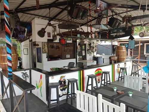 a restaurant with a bar with stools and a counter at Boaty's Beach Cottages in Calangute