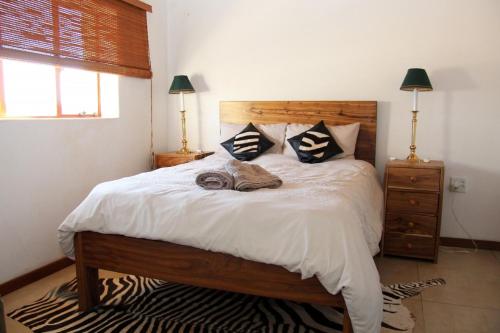 a bedroom with a large bed with two lamps at Khomas Hochland Chalet in Prospect