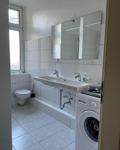 een badkamer met een wastafel en een wasmachine bij 3 Zimmer für 4 Personen - große Dachterrasse in Bremen