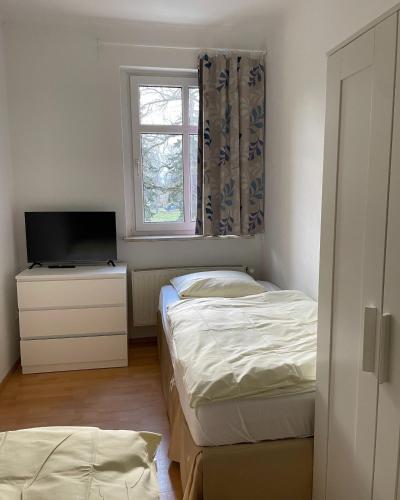 een slaapkamer met 2 bedden, een tv en een raam bij 3 Zimmer für 4 Personen - große Dachterrasse in Bremen