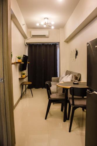 a living room with a table and chairs and a couch at RQ Cozy One Bedroom Condo, Coast Residences Pasay in Manila