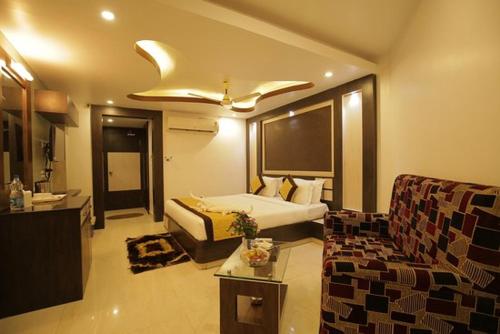 a hotel room with a bed and a couch at Hotel Goa Heritage Resort in Baga