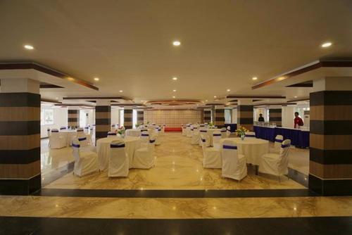 une salle de banquet avec des tables blanches et des chaises blanches dans l'établissement Hotel Goa Heritage Resort, à Baga