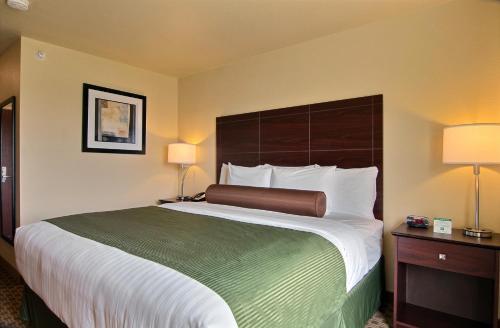 a hotel room with a large bed and two lamps at Cobblestone Inn & Suites - Linton in Linton