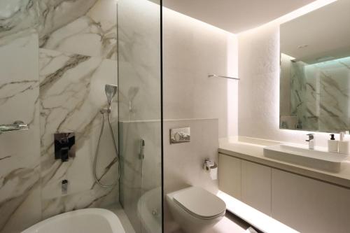 a bathroom with a shower and a toilet and a sink at Livbnb -Glam Studio in Marina, Next to Marina Walk in Dubai