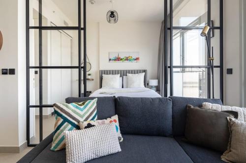 a living room with a couch and a bed at Frank Porter - Collective Tower 1 in Dubai