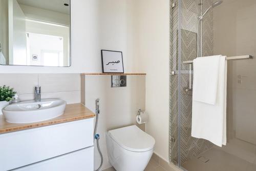 a bathroom with a toilet and a sink and a mirror at Frank Porter - Collective Tower 1 in Dubai