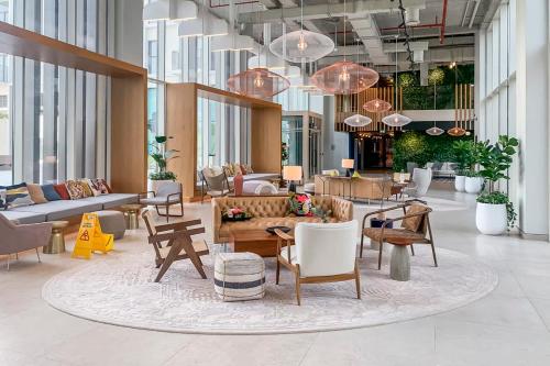 a lobby with tables and chairs in a building at Frank Porter - Collective Tower 1 in Dubai