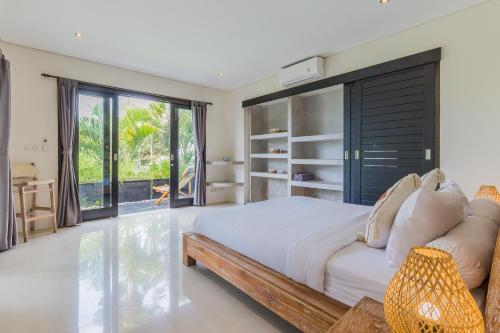 a bedroom with a large bed and a large window at Beautiful Huge 4 bedrooms Villa in Canggu in Canggu