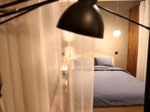 ein Schlafzimmer mit einem Bett und einer schwarzen Lampe in der Unterkunft Grey studio in Maardu in Maardu