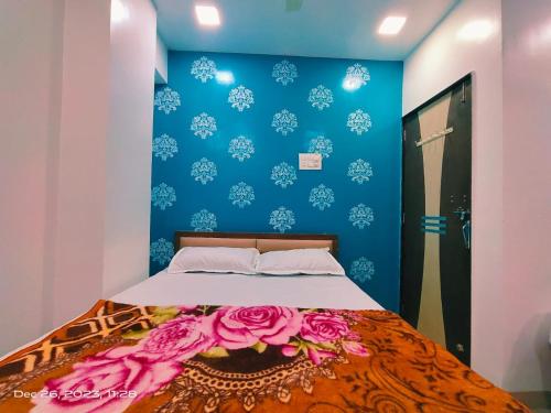 a bedroom with a bed with a blue wall at Amrit Guest House Pune in Pune