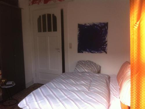 een slaapkamer met een wit bed en een deur bij Privatzimmer Wagner in Hannover