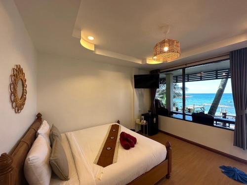 a bedroom with a bed and a couch and a window at Silver Beach Resort in Lamai