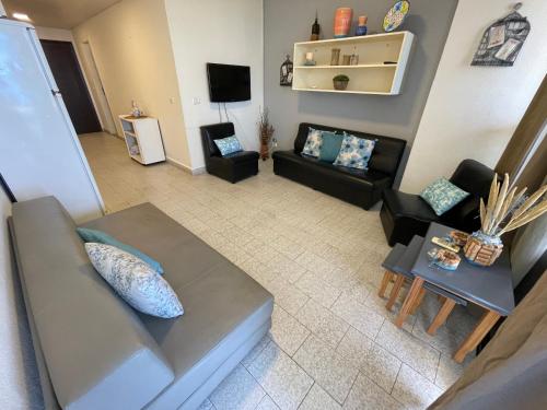 - Vistas a la sala de estar con sofá en Chalet en urbanisazion de Solemar, piscinas, tennis, futbol, Balon cesto en Al Kaslīk