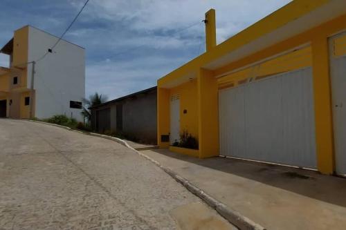 una calle vacía con un edificio blanco y amarillo en Casa Amarela em Camamu - BA en Camamu
