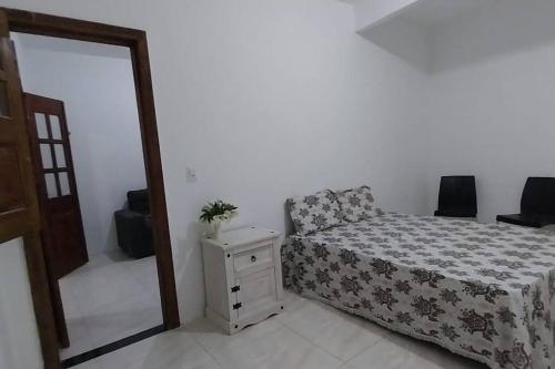 1 dormitorio con cama, tocador y espejo en Casa Amarela em Camamu - BA en Camamu