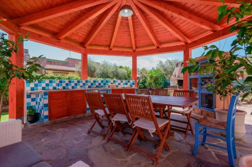 a wooden gazebo with a wooden table and chairs at Villa Rosanna in Capoterra