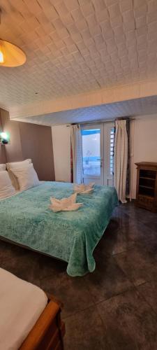 a bedroom with a large bed with a view of the ocean at Le Palmier de la Paix in Le Tampon