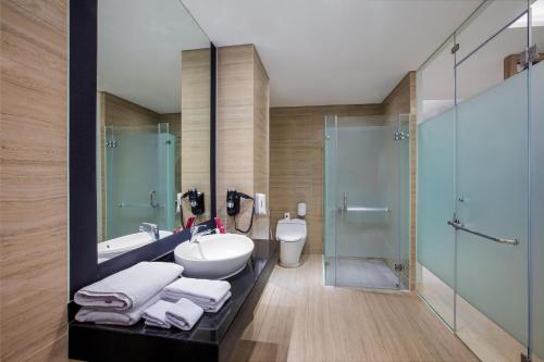 a bathroom with a sink and a shower and a toilet at favehotel Sidoarjo in Sidoarjo