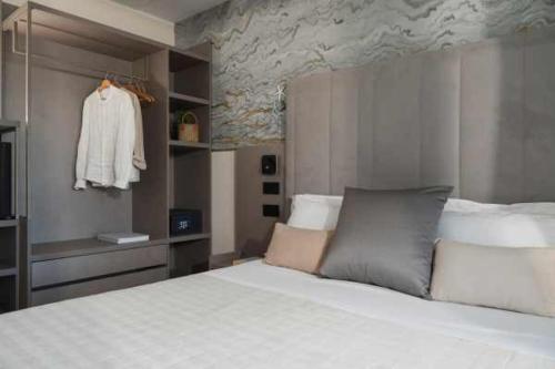 里喬內的住宿－Hotel Ascot Riccione，卧室配有白色大床和梳妆台