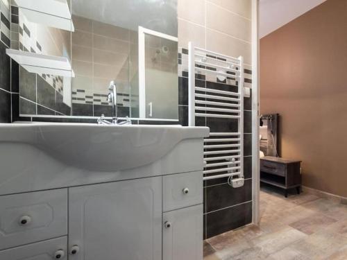 a bathroom with a white sink and a mirror at L'Atelier- appartement cosy avec cour - centre in Bourgoin