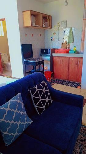 una sala de estar con un sofá azul con almohadas. en Studio 23, en Mombasa