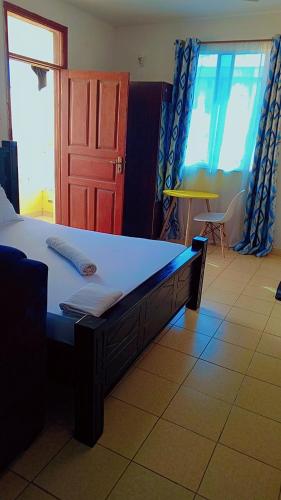 1 dormitorio con 1 cama y puerta roja en Studio 23, en Mombasa