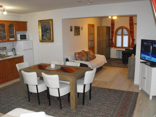 a kitchen and living room with a table and a bed at Ezüsthíd Apartman in Balatongyörök