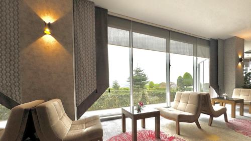 a living room with two chairs and a large window at Ramada by Wyndham Tekirdağ in Tekirdag