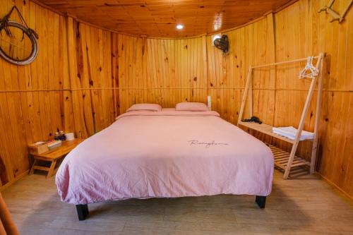 a bedroom with a bed in a wooden room at Wine Valley Homestay Dalat in Xuan An